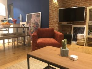 a living room with a red chair and a tv at We Collect Sunshine in Split