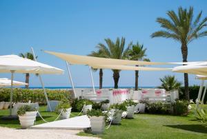 a wedding ceremony under umbrellas at the beach at Asterias Beach Hotel in Ayia Napa