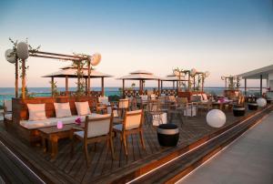 a restaurant with tables and chairs on a deck at Asterias Beach Hotel in Ayia Napa