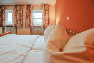 a bedroom with a bed with white sheets and pillows at Ferienwohnung Alte Hofmark Neumayer in Bad Birnbach