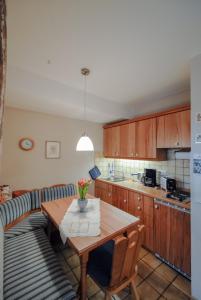 a kitchen with a wooden table and a couch at Ferienwohnung Alte Hofmark Neumayer in Bad Birnbach