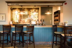 a bar with wooden chairs and a blue counter at The Saracens Head in Stafford +14 photos
