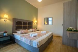 
a hotel room with two beds and two lamps at Alianthos Beach Hotel in Plakias
