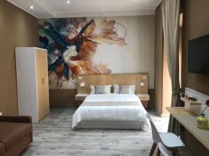 sypialnia z łóżkiem i obrazem na ścianie w obiekcie Parthenope Rooms w mieście Neapol