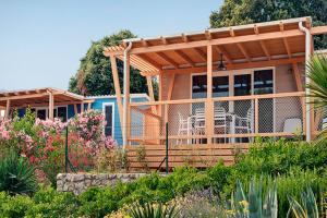 a house with a pergola in a garden at Marina Camping Resort by Valamar in Rabac