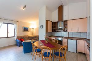 kuchnia i salon ze stołem i krzesłami w obiekcie Apartment Stanka w mieście Cavtat