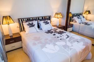 1 dormitorio con 1 cama grande y espejo grande en Apartment Delfines Sand Corralejo By Holidays Home, en Corralejo