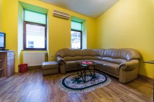 a living room with a leather couch and a table at Apartments & Rooms Fountain in Bihać