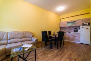 a living room with a couch and a table and a kitchen at Apartments & Rooms Fountain in Bihać