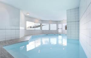 una gran piscina en una habitación con azulejos blancos en Résidence Odalys Les Belles Roches, en Notre-Dame-de-Bellecombe