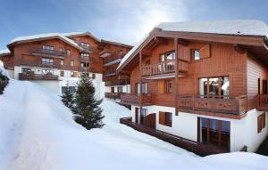 un edificio con la neve davanti di Résidence Odalys Les Belles Roches a Notre-Dame-de-Bellecombe