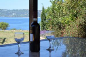 a bottle of wine sitting on a table with two glasses at Marvelous Sea View Eco Apt in Ammouliani