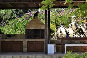 a brick barbecue grill with flowers in the background at Marvelous Sea View Eco Apt in Ammouliani