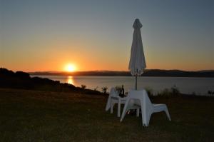a table and two chairs and an umbrella at sunset at Marvelous Sea View Eco Apt in Ammouliani