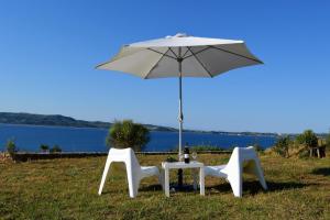 a table and two chairs under an umbrella at Marvelous Sea View Eco Apt in Ammouliani