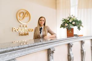 a woman standing at a counter in a hotel room at Hotel Polustrovo in Saint Petersburg