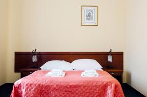 a bedroom with a bed with two towels on it at Pałac Koronny Noclegi & Wypoczynek in Wodzisław