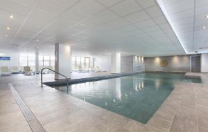 - une grande piscine dans un bâtiment avec des chaises dans l'établissement Résidence Prestige Odalys Front de Neige, à Plagne Villages