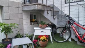 uma bicicleta estacionada ao lado de uma escada com flores em neat house hongdae em Seul