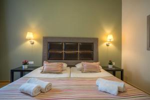 a bedroom with a large bed with two pillows at Alianthos Beach Hotel in Plakias