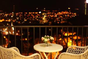 una mesa con un jarrón de flores en el balcón en Tbilisi View Hotel, en Tiflis