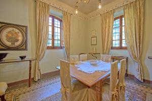 a dining room with a table and chairs at Villa Primula by PosarelliVillas in Cortona