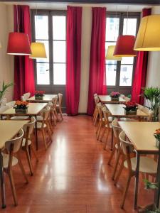 um restaurante com mesas e cadeiras e cortinas vermelhas em Hotel Gambetta em Bordeaux