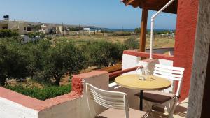 a table and chairs on the balcony of a house at Antikristo Rooms in Karteros