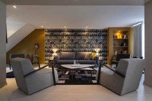 a living room with a couch and a table at Résidence & Spa Le Prince Régent in Paris