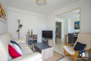 a living room with two white chairs and a television at Spacious 2 bedroom near city centre - Dodo et Tartine in Toulon