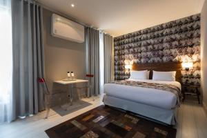 a bedroom with a bed and a desk and a window at Résidence & Spa Le Prince Régent in Paris +23 photos