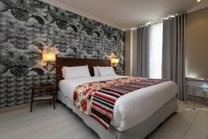 a hotel room with a large bed and a wall mural at Résidence & Spa Le Prince Régent in Paris
