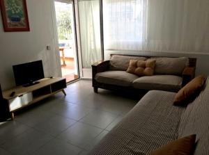 a living room with a couch and a tv at Apartamento Elia Villa África in Aguadulce