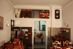 a dining room with a table and a clock on the wall at Hotel Pension Schmellergarten in Munich