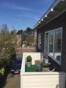 een huis met een veranda met twee potplanten erop bij Studio De Laan in Zandvoort
