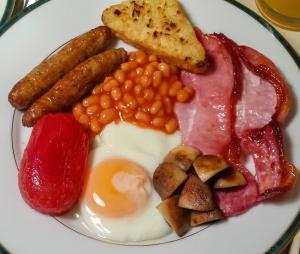 a plate of breakfast food with eggs bacon beans and toast at Brambling Fields B&B in Malton