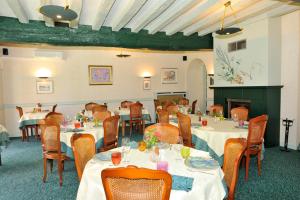 een grote eetkamer met tafels en stoelen bij LOGIS - Hôtel Restaurant Les Tilleuls in Saint-Florentin