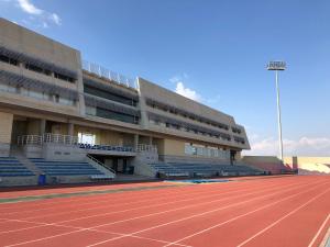 an empty stadium with a tennis court and bleachers at Allegra GSP Sport Center in Nicosia