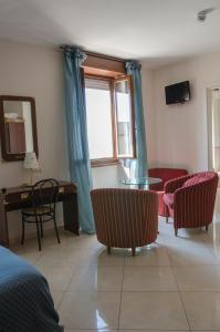 ラツィーゼにあるHotel Miralagoのリビングルーム(椅子、テーブル付)、窓が備わります。