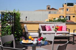 a patio with a table and chairs and a couch at Piccola Navona Roof Garden in Rome
