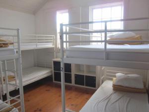 a room with three bunk beds and a window at Hostel Prime Guimaraes in Guimarães