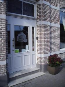 una porta bianca su un edificio di mattoni con finestra di Hotel Hooghuys a Hamont