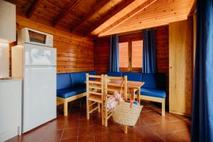 cocina con mesa, sillas y nevera en Camping La Llosa, en Cambrils