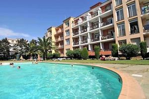 a large swimming pool in front of a large building at Marina Beach Hollidays Mimosa in Empuriabrava