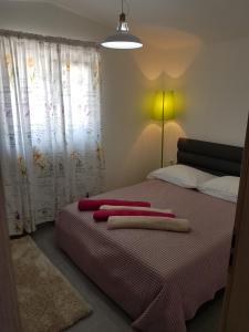 una camera da letto con un letto con asciugamani rossi di Rafael a Okrug Gornji