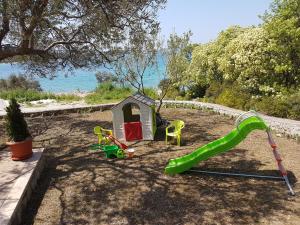 a playground with a slide and a play house at Rafael in Okrug Gornji