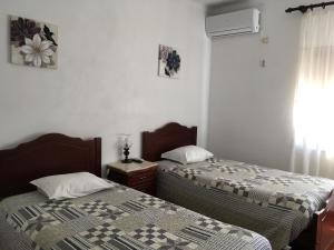 1 Schlafzimmer mit 2 Betten und einem Fenster in der Unterkunft Hospedaria O Castelo in Portel