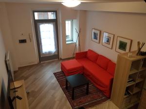 ein Wohnzimmer mit einem roten Sofa und einem Tisch in der Unterkunft La Corte sul Naviglio in Corsico