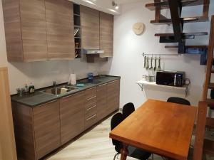 cocina con fregadero y mesa de madera en La Corte sul Naviglio en Corsico