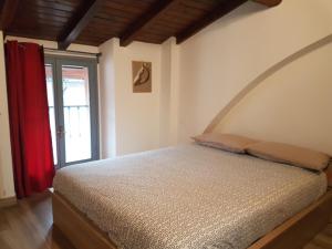 a bedroom with a bed and a red curtain at La Corte sul Naviglio in Corsico